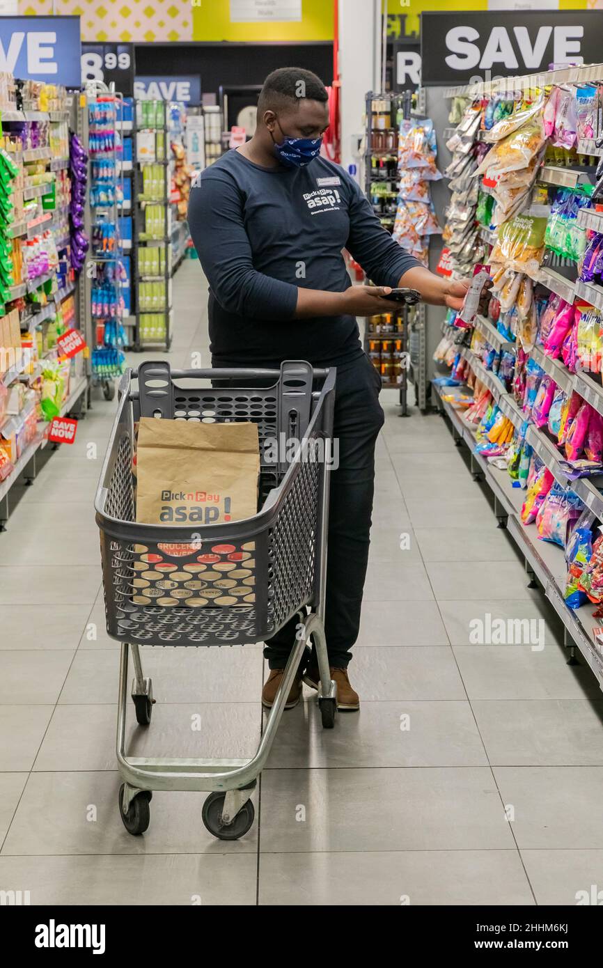 Cape Town, Afrique du Sud - 9 septembre 2021 : un membre du personnel cueille des produits à partir de l'étagère pour un service de livraison express à domicile Banque D'Images