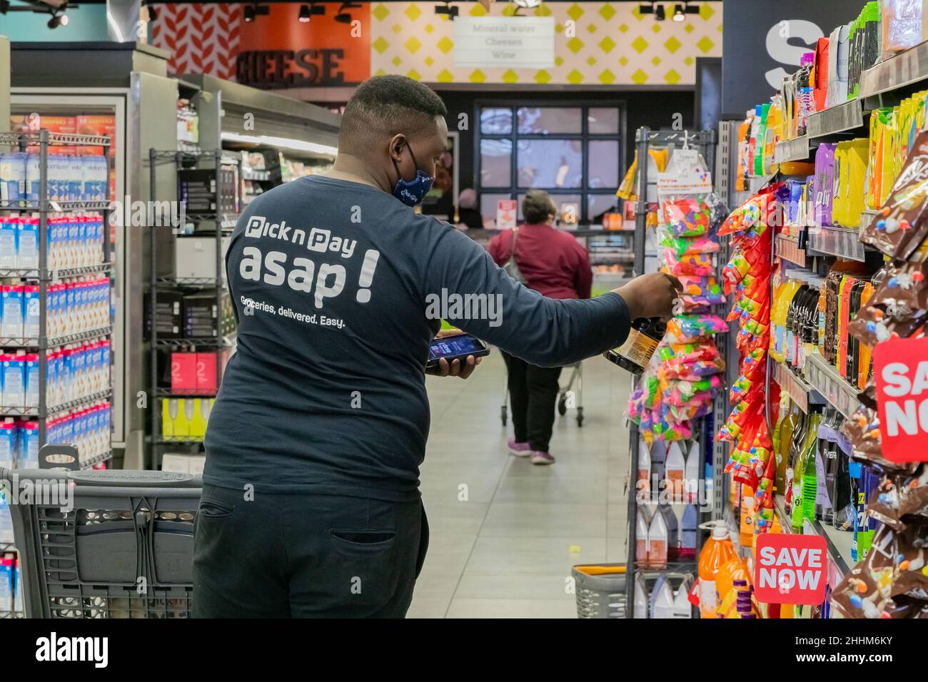 Cape Town, Afrique du Sud - 9 septembre 2021 : un membre du personnel cueille des produits à partir de l'étagère pour un service de livraison express à domicile Banque D'Images
