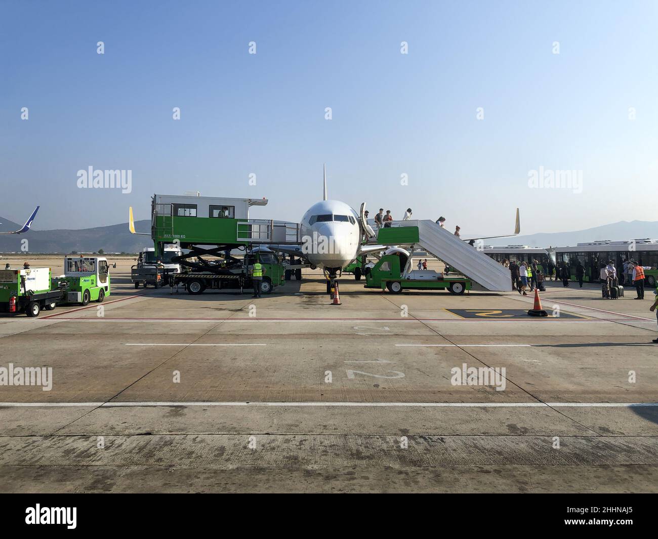 Aéroport Sabiha Gokcen, Istanbul, Turquie - 15 janvier 2022 : vue avant de l'avion passager relié à gangway. Les gens qui sont en train de descendre de l'avion pour prendre le bus Banque D'Images