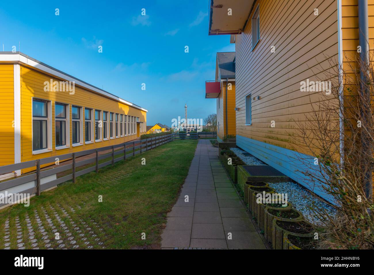 Bâtiments scolaires (à gauche) et un quartier vivant, borth peint en jaune, architecture sur l'île de la mer du Nord d'Heligoland, Allemagne du Nord, Europe Banque D'Images