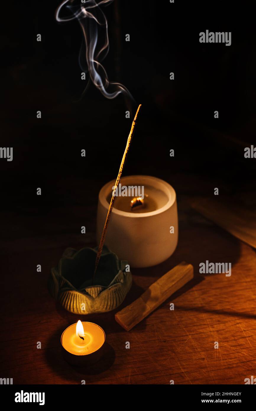 Bâtons d'arôme d'Encens couvant sur la table porte-lotus et bougie dans l'obscurité.Zen, méditation, santé mentale zone de confort Banque D'Images