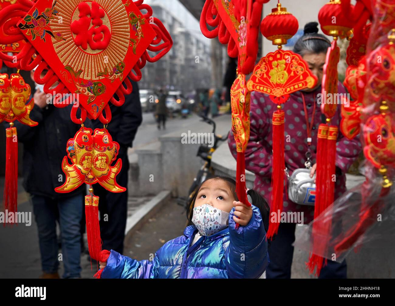 (220125) -- XI'AN, 25 janvier 2022 (Xinhua) -- Un enfant choisit des pendaisons murales festives à Xi'an, dans la province de Shaanxi, dans le nord-ouest de la Chine, 25 janvier 2021.Le 24 janvier, Xi'an a autorisé toutes les zones classées à risque élevé et moyen pour la COVID-19.(Xinhua/Tao Ming) Banque D'Images