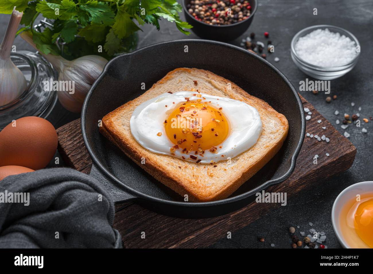 Petit-déjeuner avec œufs frits dans une poêle sur fond sombre. Banque D'Images