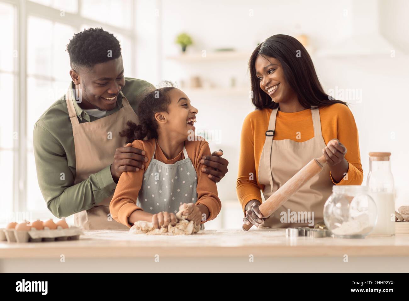 Heureux parents africains et fille de pâte à pétrir dans la cuisine Banque D'Images