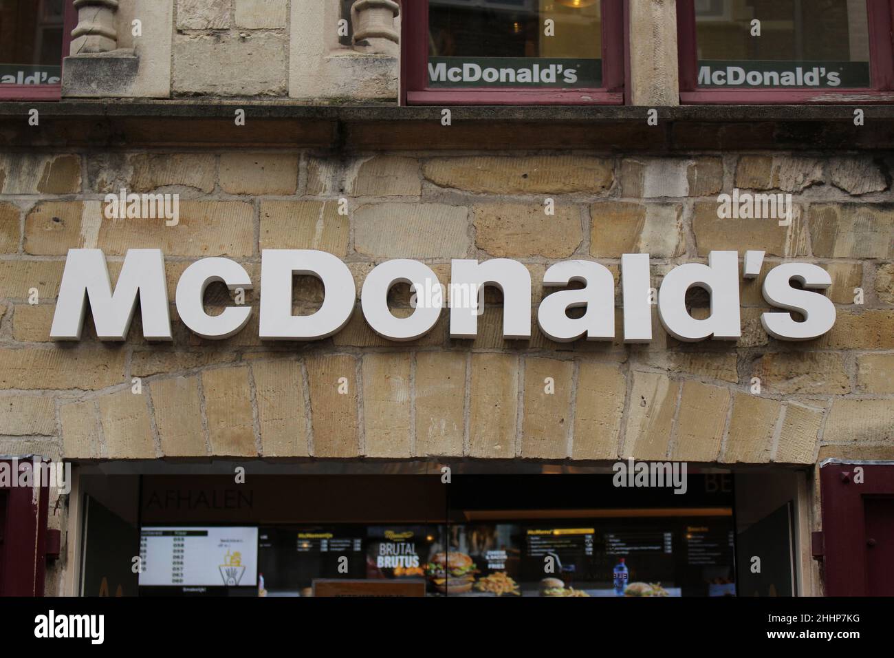 BRUGES, BELGIQUE - 23 JANVIER 2022 : le signe de McDonald's contre un mur de pierre dans une vieille ville Banque D'Images