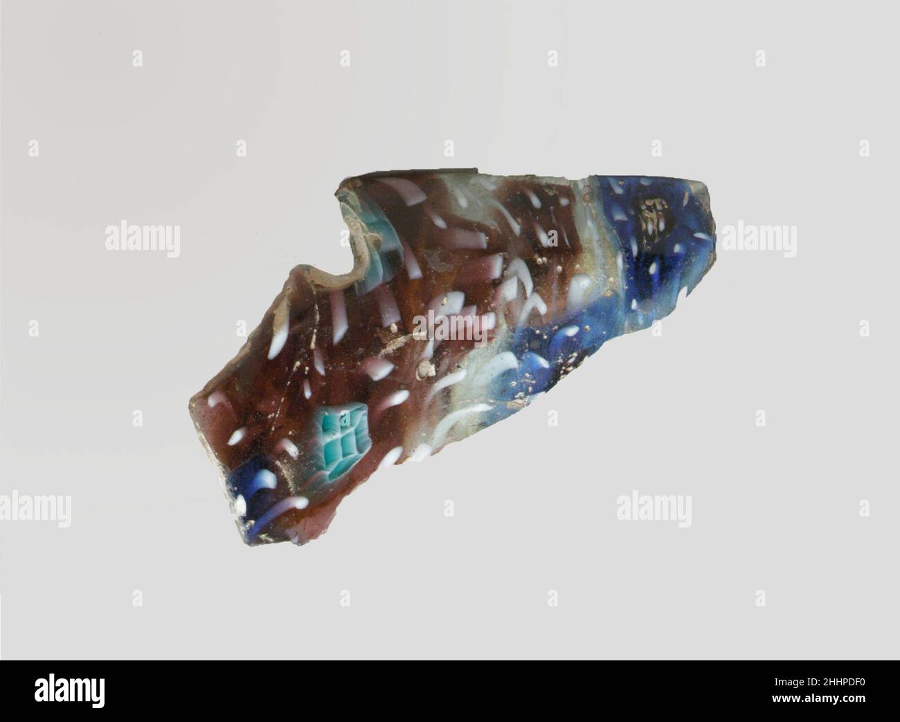 Fragment de bol nervuré en mosaïque de verre fin du 1st siècle C.-B.–début du 1st siècle A.D. Roman violet translucide, bleu cobalt et bleu turquoise clair, blanc opaque et incolore.rebord arrondi en saillie; côté bombé.motif en mosaïque formé de grandes sections polygonales de deux canes ou plus;l'un dans un sol violet avec un cercle de tiges blanches autour d'un motif central de petits carrés en bleu turquoise entouré en blanc, et l'autre dans un sol bleu avec un cercle de tiges blanches autour d'un carré central en violet avec des points blancs,et des taches irrégulières, incolores, avec des tiges blanches; à l'extérieur, deux Banque D'Images