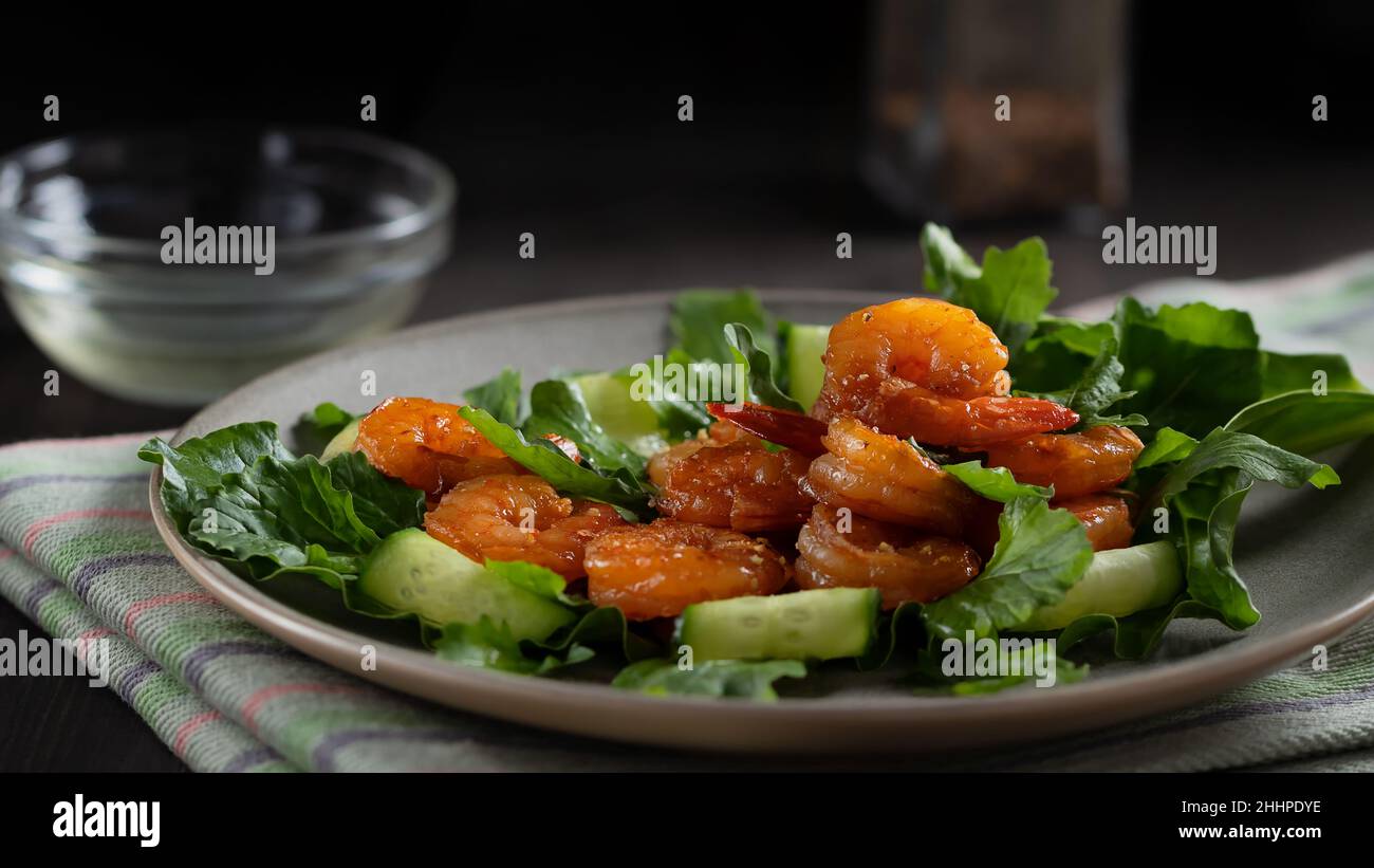 Salade fraîche aux crevettes grillées, concombres et arugula magnifiquement servis sur une assiette. Banque D'Images