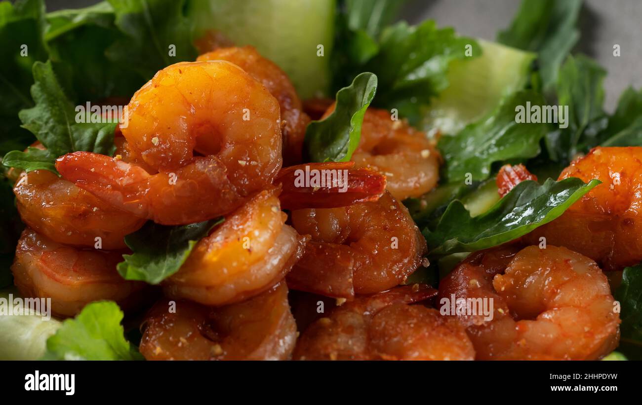 Salade fraîche aux crevettes grillées, concombres et arugula, servie sur une assiette, en gros plan. Banque D'Images