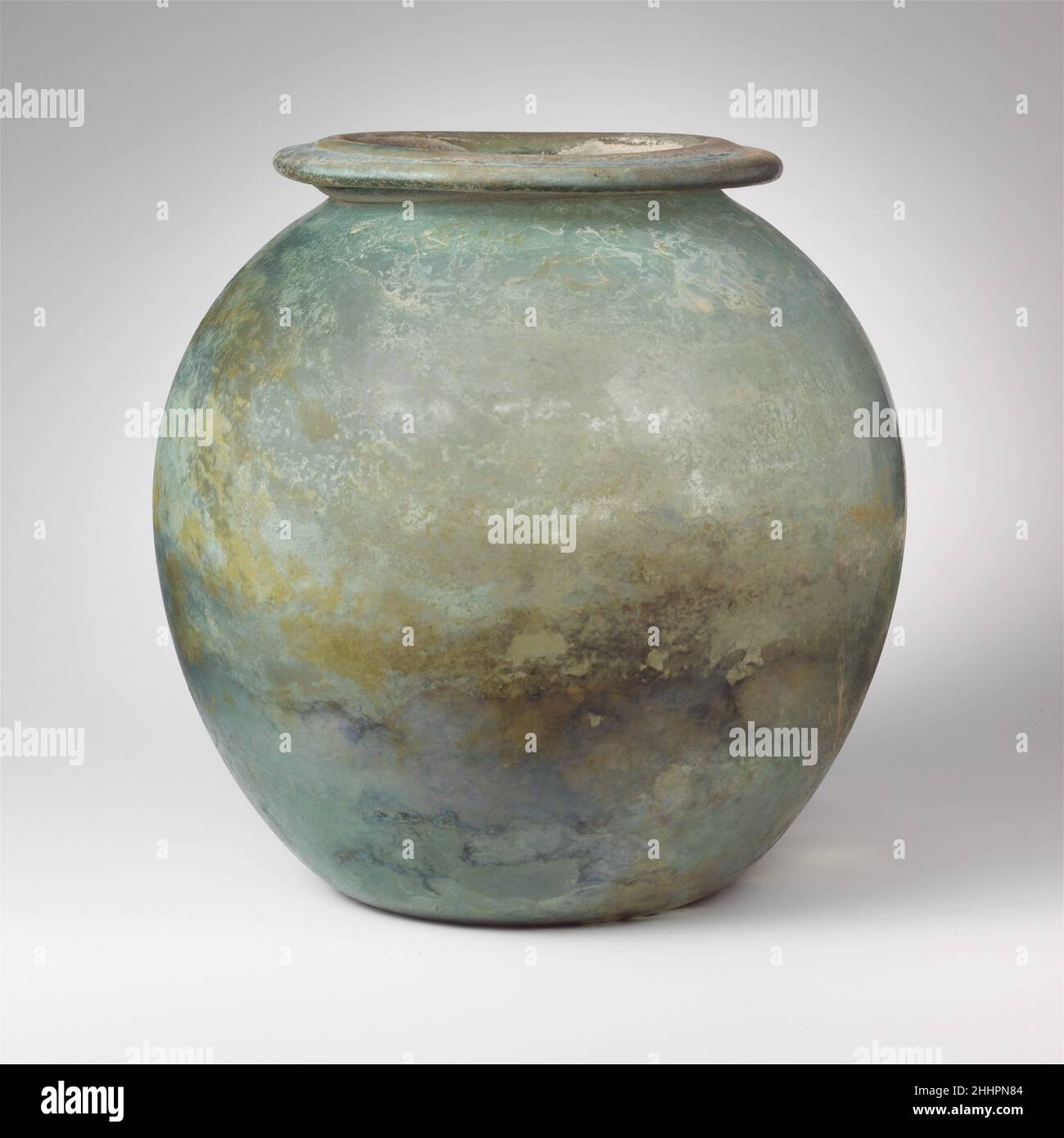 Rte de verre (olla) mi-1st–2nd Century A.D. Roman bleu translucide vert.large, éverté, rebord tubulaire, en repliant, vers l'extérieur, vers le bas, rond et à l'intérieur, avec surface supérieure biseautée; corps ovoïde; fond concave profond.intact, mais avec une fissure interne allant verticalement du bord au sommet du côté; quelques bulles; morcellement, piqûres, dépôt de limpiqué,Faible iridesence, et des intempéries blanchâtres patcheuses sur l'extérieur, l'envasement limy et les intempéries épaisses avec l'iridesence brillante sur l'intérieur.bocal ovoïde Uni.Urne en verre (olla) 245163 Banque D'Images