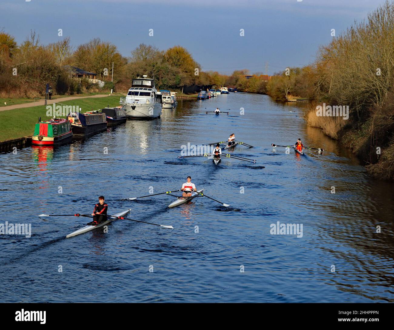 Dans un matin d'hiver lumineux, frais et croustillant, une flotte de 6 canoës passe devant des bateaux-canaux amarrés sur le canal Gloucester et Sharpness au pont Sellars Banque D'Images