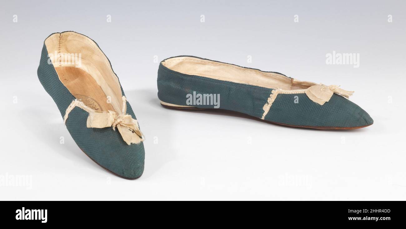 Chaussons de soirée 1815–20 Vandervell réalisés dans une soie à motifs intéressants avec des détails contrastés attrayants, ces pantoufles illustrent la transition de l'orteil très pointu et le développement vers le style complètement héelleux des chaussures pour femmes qui se sont produites entre 1800 et 1830.La semelle très étroite illustre également une tendance à venir pour les chaussons incroyablement fins et serrés.La conception de ces chaussures est particulièrement raffinée, avec la pointe, la gorge et l'étiquette formant une belle courbe répétée.L'assertion des courbes à la gorge et à l'orteil souligne le mouvement du Banque D'Images
