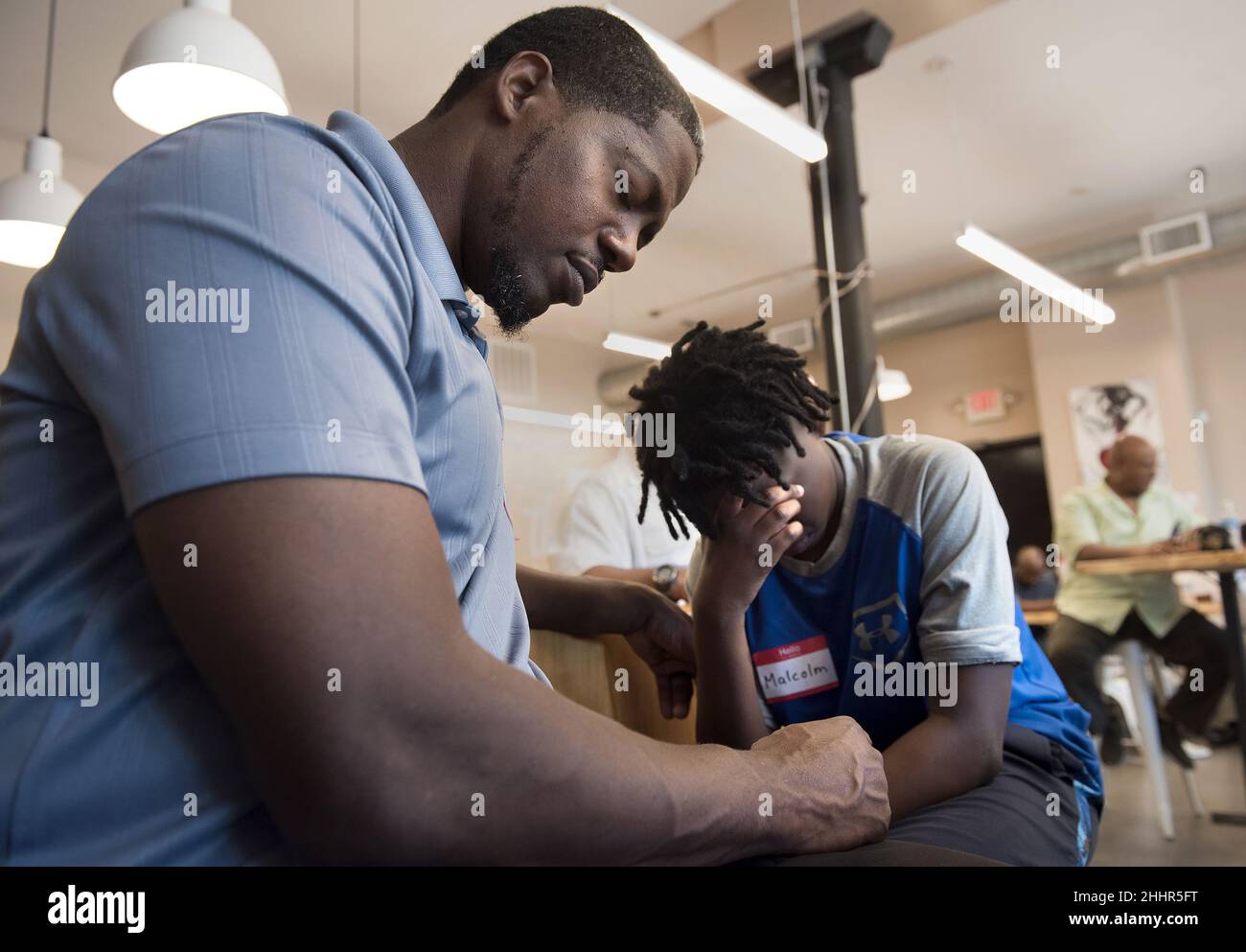 Melvin Wisham (à gauche) et son fils Malcolm Wisham, 13 ans, font une pause dans la prière pendant un petit déjeuner pour les pères et leurs fils à Saint Louis, Missouri, Etats-Unis. Banque D'Images