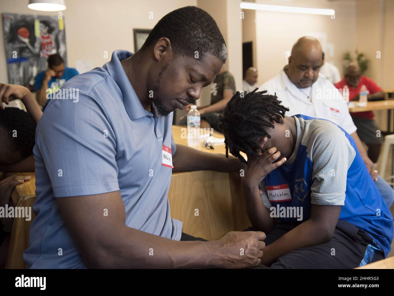 Melvin Wisham (à gauche) et son fils Malcolm Wisham, 13 ans, font une pause dans la prière pendant un petit déjeuner pour les pères et leurs fils à Saint Louis, Missouri, Etats-Unis. Banque D'Images