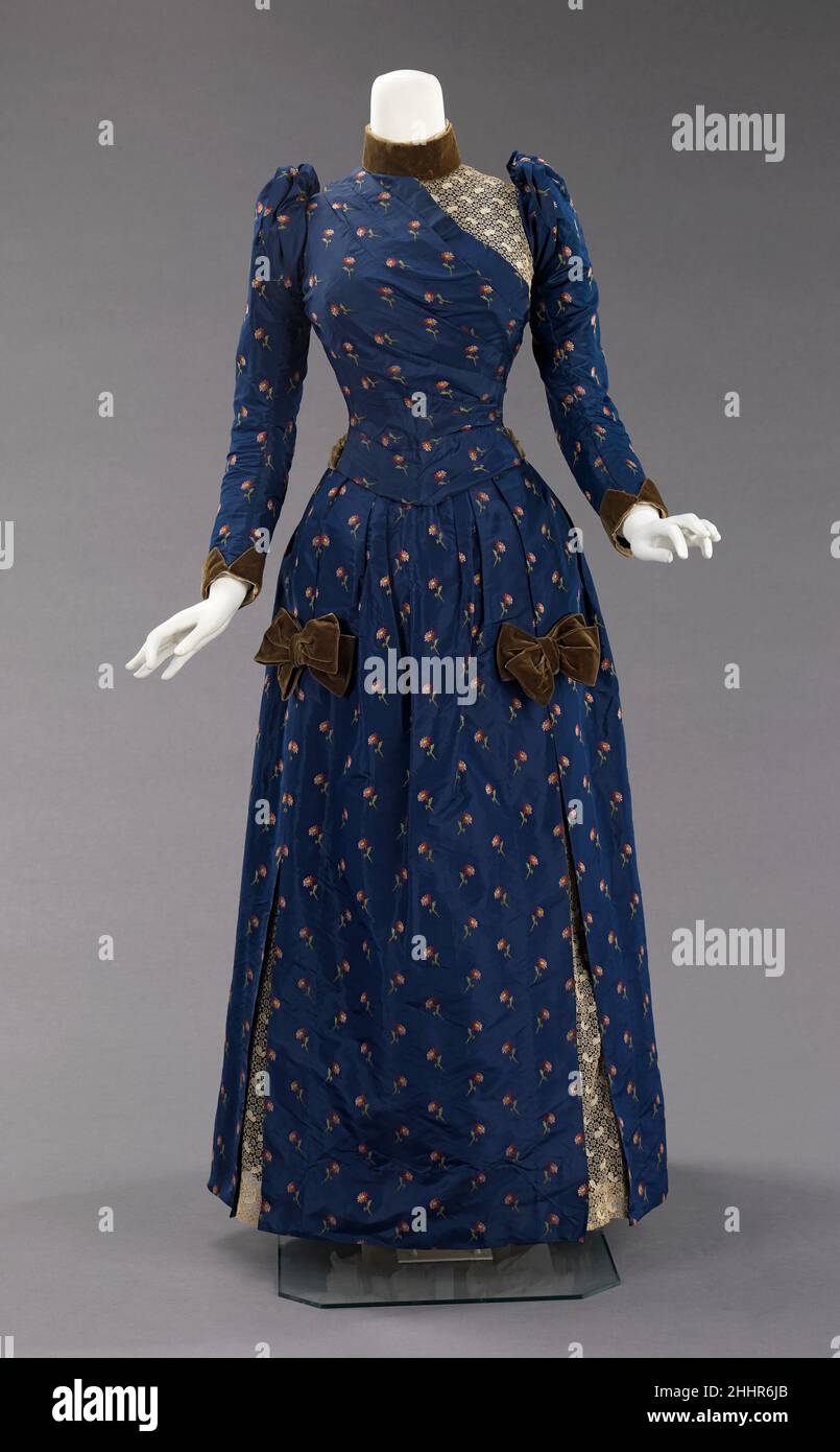 Robe d'après-midi ca.1888 American la silhouette d'agitation, bien que principalement associée à la deuxième moitié du 19th siècle, a commencé dans les modes antérieurs comme une simple bosse à l'arrière de la robe, comme avec la fin 17th-début 18th siècle mantuas et fin 18th- début 19th siècle Empire robes.La silhouette pleine d'agitation avait sa première apparence victorienne à la fin de 1860s, qui a commencé comme la plénitude dans les jupes se déplaçant à l'arrière de la robe.Cette plénitude a été dressée en cravates pour la marche qui a créé une bouffée à la mode.Cette bouffée tendance s'est développée et a ensuite été construite avec su Banque D'Images