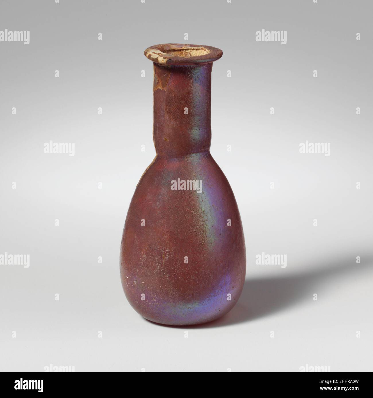 Flacon de parfum en verre 1st Century A.D. Roman incolore (?).Rim replié sur et dans la bouche horizontale; court, col cylindrique, outilé autour de la base; corps piriforme; petit, fond plat.intact; beaucoup de bulles;piqûres profondes et intempéries irisées.Flacon de parfum en verre 239647 Banque D'Images