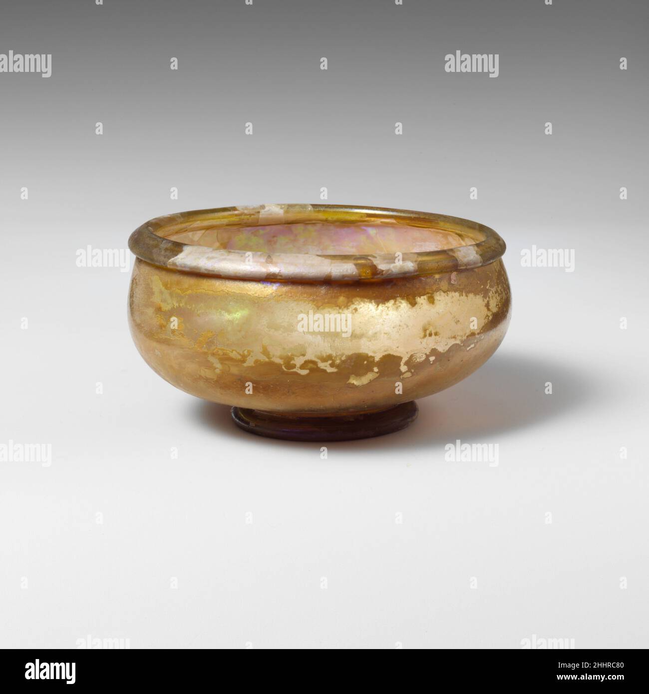 Bol en verre 2nd–3rd Century A.D. Roman jaune verdâtre translucide.rebord replié vers l'extérieur et vers le bas, formant un col rond partiellement tubulaire à la bouche avec lèvre intérieure; côtés bombés dans l'anneau de base tubulaire bas intégral; fond plat avec des traces de pontil et un léger coup.intact; peu de bulles;morcellement, piqûres légères et iridescent sur l'extérieur, crémeux, iridescent sur l'intérieur.Bol en verre 239845 Banque D'Images