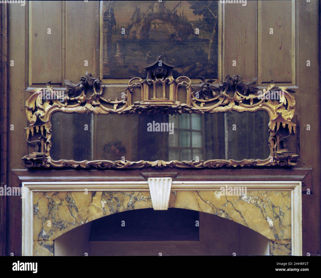Verre 1750–75 fait en Angleterre, le verre rococo sculpté et doré de la salle Marmion a probablement été installé lorsque la pièce a été peinte en 1770s.Le cadre est doté de scrollwork percé, de rouleaux en C de feuilles d'acanthus et d'un pavillon chinois central considéré comme « exotique » selon les normes du XVIIIe siècle.Le verre à l'aspect était probablement commandé sur mesure pour s'adapter à l'espace au-dessus de la cheminée, où il était vissé dans le mur et considéré comme un accessoire architectural permanent.Verre à l'aspect.1750–75.PIN, plâtre doré.Fabriqué en Angleterre Banque D'Images