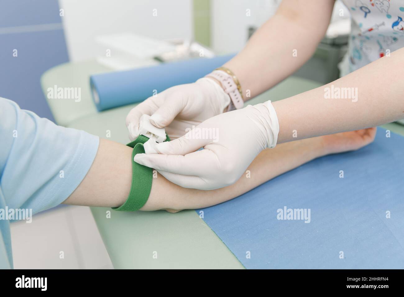 Effectuer un test sanguin sur une veine dans la salle de traitement.L'infirmière pousse une seringue avec une aiguille dans la main du patient.Ecouvillon appuyé contre le Banque D'Images
