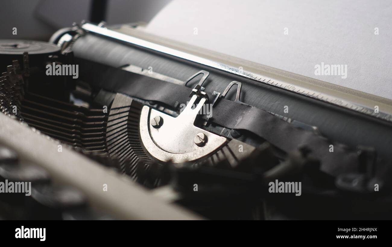 Un auteur travaillant sur une vieille machine à écrire mécanique rétro Banque D'Images