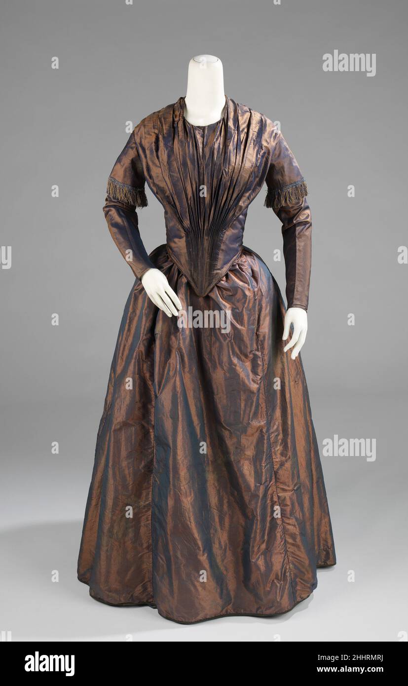 Robe d'après-midi ca.1845 américain le bruissement de la soie était un son qui incarnait l'élégance au milieu du 19th siècle.Cette belle robe aurait combiné l'attrait visuel avec l'attrait auditif simplement par son choix de taffeta.la silhouette féminine du milieu du 19th siècle se composait d'un corseted bodyce ajusté et de larges jupes pleines.Les jupes coniques se sont développées entre les 1830s, quand la taille haute de la silhouette de l'Empire a été abaissée et les jupes sont devenues plus en forme de cloche, à la fin de 1860s, quand la plénitude des jupes ont été tirées à l'arrière et l'agitation dev Banque D'Images