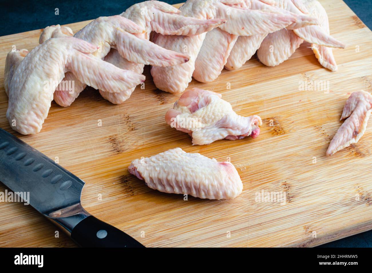 Couper les ailes de poulet cru en Wingettes et en Drumettes : couper des ailes de poulet non cuites entières en morceaux Banque D'Images