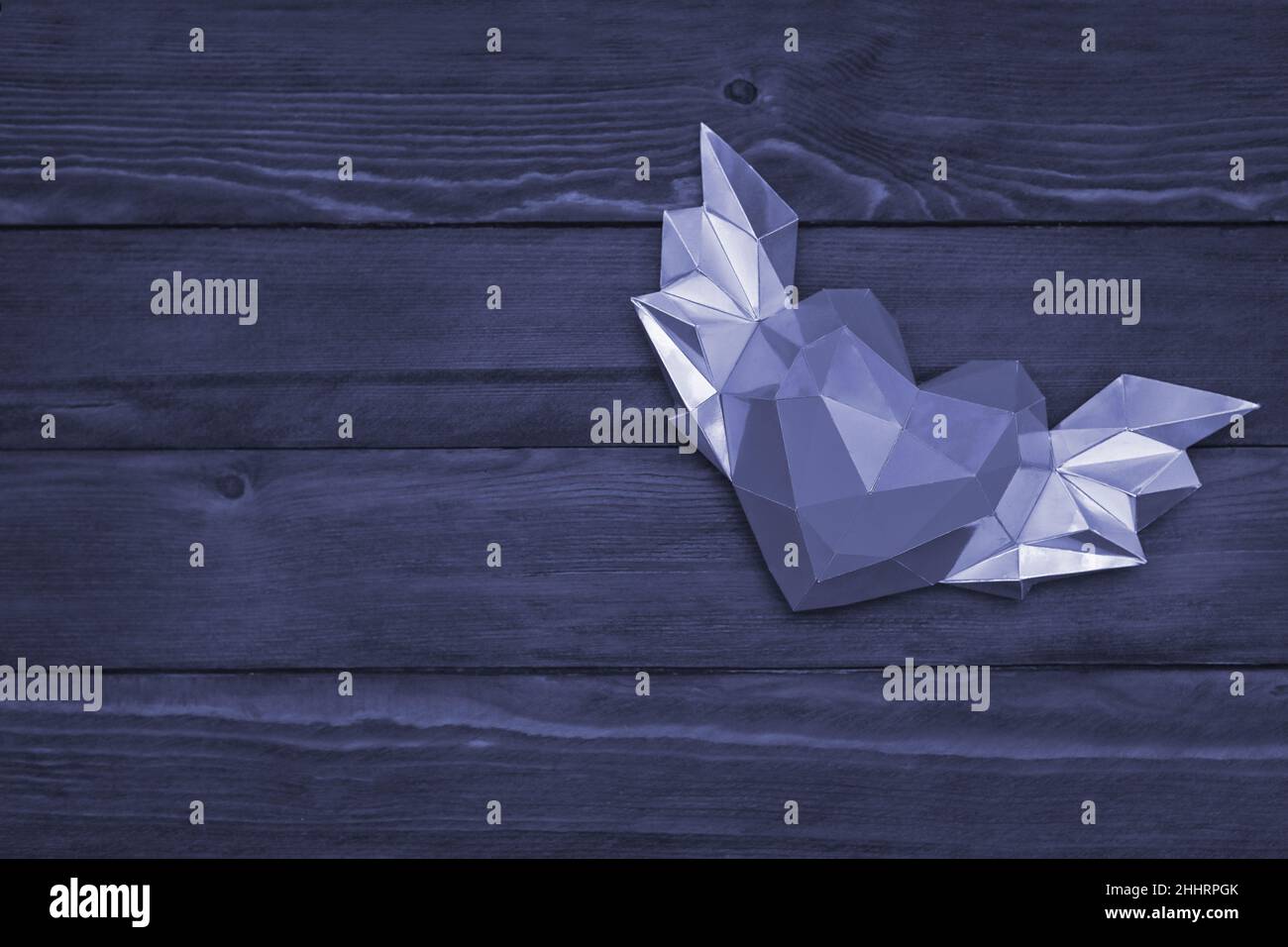 Un coeur avec des ailes sur un fond en bois. Forme polygonale.La photo est teintée d'une couleur très Peri Banque D'Images