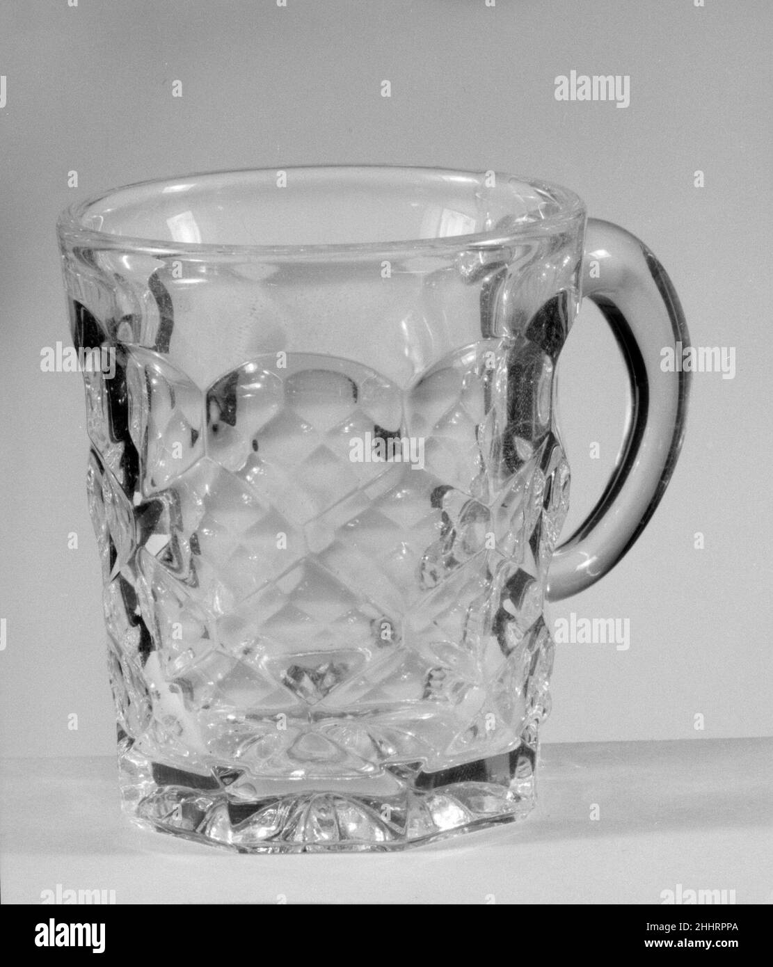 Mug 1850–70 avec le développement de nouvelles formules et techniques, la technologie de pressage du verre s'était nettement améliorée à la fin de 1840s.À ce moment-là, les tablewares pressés étaient produits dans de grands ensembles de correspondance et des formes innombrables.Au milieu de l'année 1850s, le verre incolore et les patrons géométriques simples dominaient.Répondant à la demande de produits de restauration à prix modéré, l'industrie du verre aux États-Unis s'est largement développée et de nombreuses usines ont fourni des verres pressés moins chers au marché en pleine croissance.À l’exposition de l’industrie de toutes les nations au Crystal Palace de New York en 1853, Banque D'Images