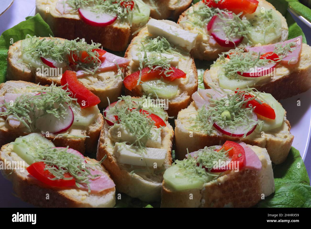 Sandwich club avec saucisse sur une assiette blanche.Club sandwich avec fromage et salade verte traditionnelle maison Banque D'Images