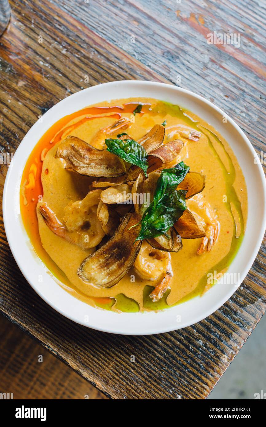 Un plat de curry épicé de crevettes à la noix de coco est servi dans un restaurant thaïlandais Banque D'Images