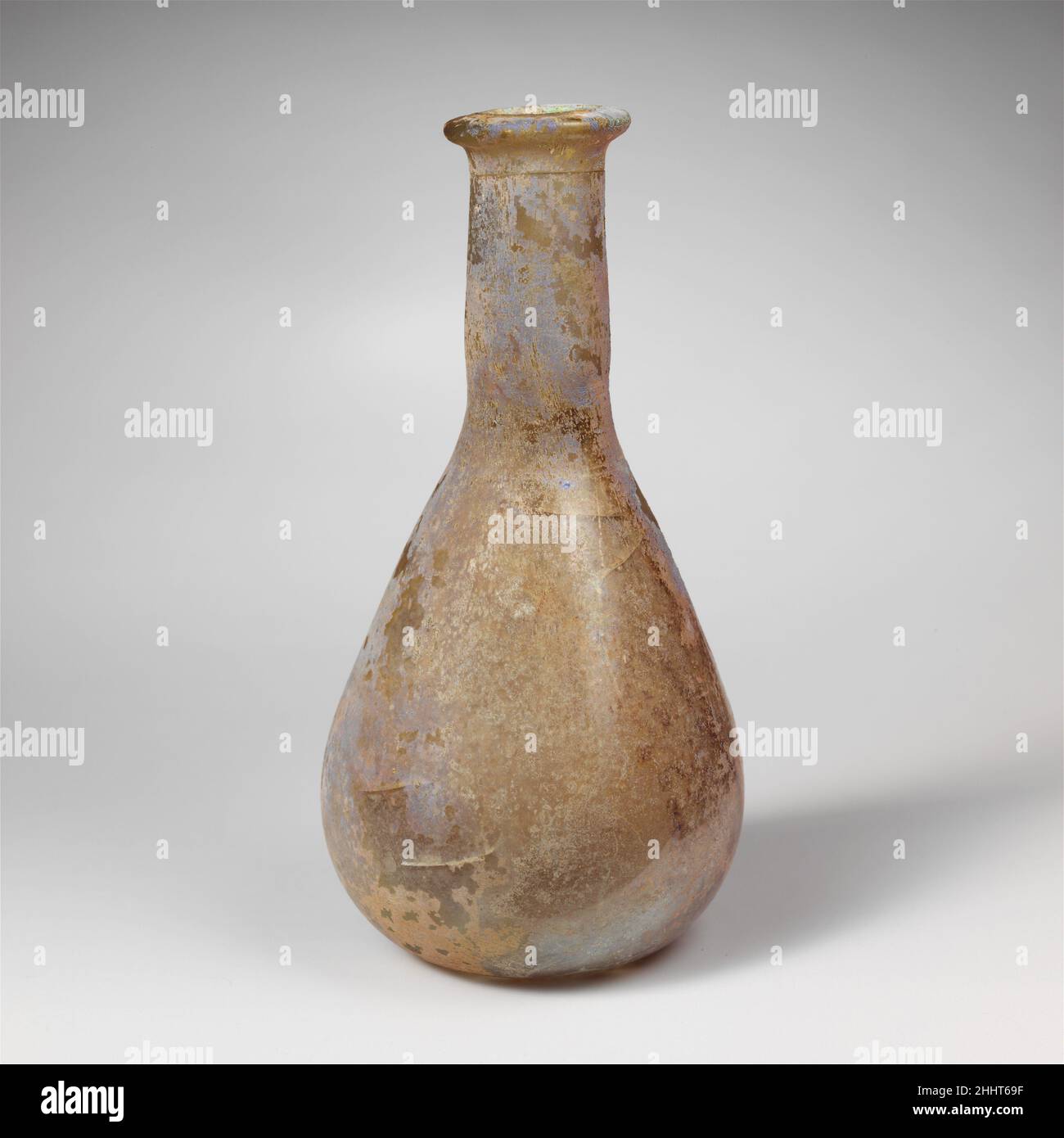 Flacon de parfum en verre 1st–2nd Century A.D. Roman translucide bleu pâle vert.rebord épais plié, au-dessus et à l'intérieur, aplati sur le dessus; col cylindrique avec bande de repères d'outillage autour de la base; corps piriforme; plat bottom.Complete mais fissure autour du haut du cou, avec autres fissures internes dans le corps;quelques bulles plus grosses et plus piquantes; morcellement, piqûres et intempéries irisées, avec un peu d'enrobissement de sol et une botte lâche à l'intérieur.Flacon de parfum en verre 244637 Banque D'Images