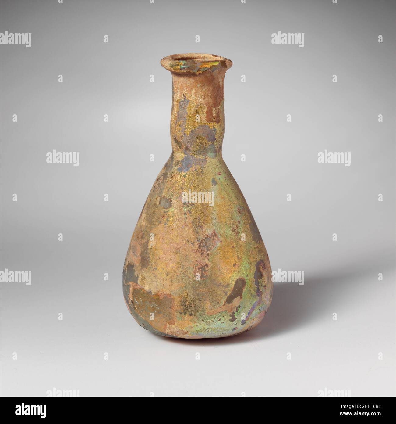 Flacon de parfum en verre 1st Century A.D. Roman incolore avec une teinte bleu pâle.rebord replié, aplati sur le dessus et d'un côté pour former un bec; col cylindrique court, avec un retrait arrondi autour de la base; corps conique avec une courbe arrondie à un fond légèrement convexe.intact; peu de bulles d'épingle;piqûres, morcellement et intempéries irisées, avec un peu d'entruction de sol à l'intérieur.Flacon de parfum en verre 244640 Banque D'Images