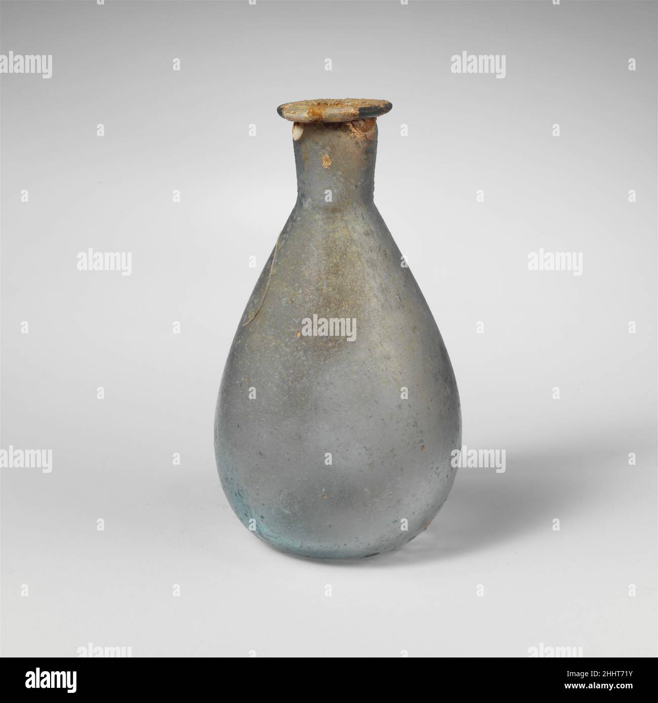 Flacon de parfum en verre 1st Century A.D. Roman translucide bleu clair vert. Rebord incliné replié, au-dessus et à l'intérieur, formant une légère constriction à la bouche; col cylindrique court, tapissant vers le bas et légèrement incliné autour de la base; corps ovoïde; légèrement concave bottom.Complete, mais avec des fissures dans le rebord, le cou et la partie supérieure du corps;piquer et quelques grosses bulles; piqûres et morcellement à l'extérieur, et taches d'intempéries irisées sur la jante et l'intérieur.Flacon de parfum en verre 244646 Banque D'Images