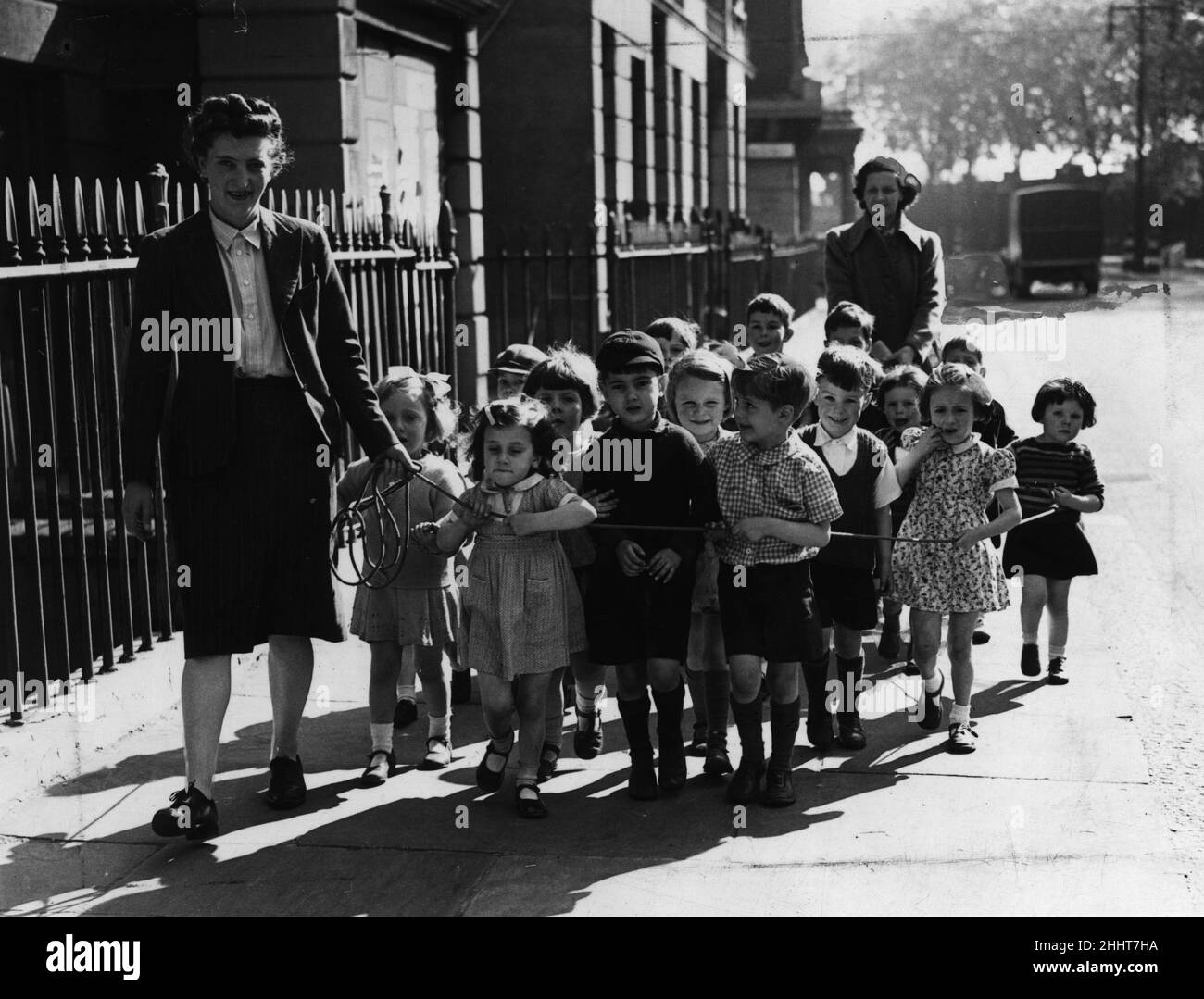 Une infirmière de la garderie Pimlico Day emmène les enfants à pied, les gardant sur une corde pour leur sécurité dans les rues animées de Londres pendant la Seconde Guerre mondiale.5th juillet 1943. Banque D'Images