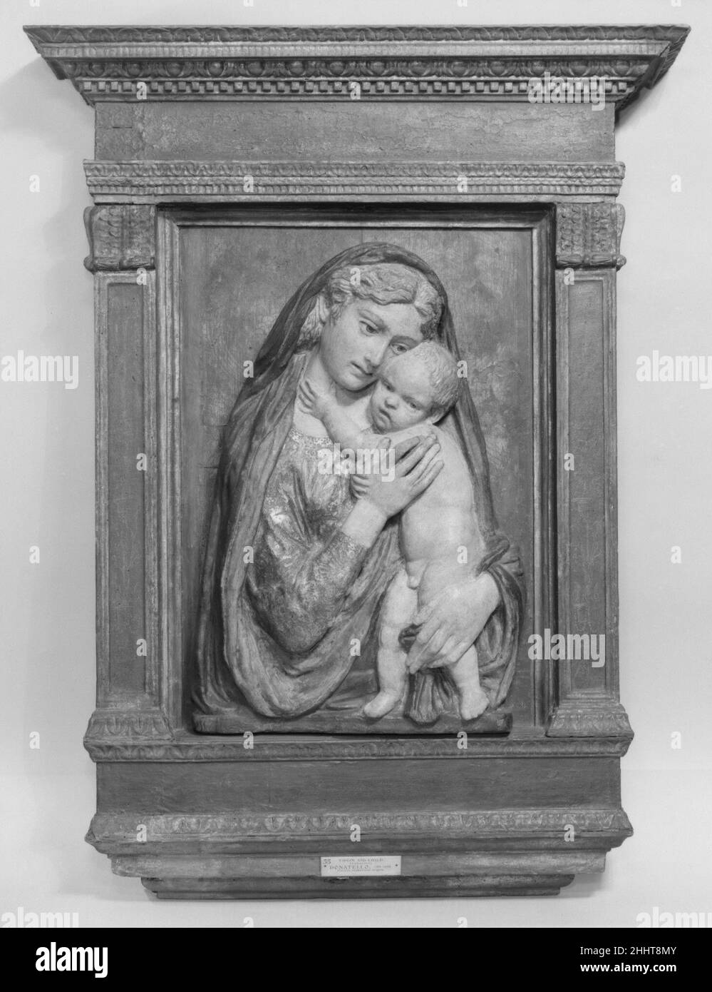 Madonna et l'enfant 15th siècle École de Donatello Italien abritant le Christ-enfant sous son manteau, Marie presse son chèque contre sa tête.Son geste d'amour l'identifie comme la Vierge de la tendresse (Eléusa) un type sacré qui dérive des icônes peintes byzantines.Ce relief en terre cuite a été créé à partir d'argile humide qui a été tiré dans un four, et par la suite embelli avec des couleurs dorées et vives.Ces sculptures ont contribué aux effets texturés richement humés typiques des intérieurs ecclésiastiques et domestiques de la Renaissance.Madonna et l'enfant.École de Donatello (italien, Flo Banque D'Images