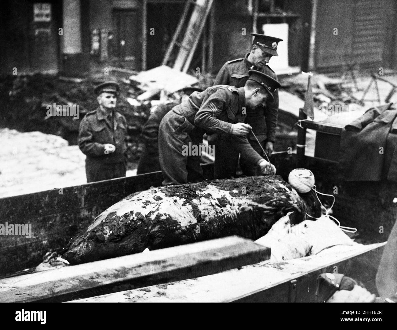 Des membres de l'équipe d'élimination de la bombe mesurent la longueur d'une bombe à retardement prise dans un magasin de Brixton Hill, dans le sud de Londres pendant la deuxième Guerre mondiale.Vers 1940. Banque D'Images