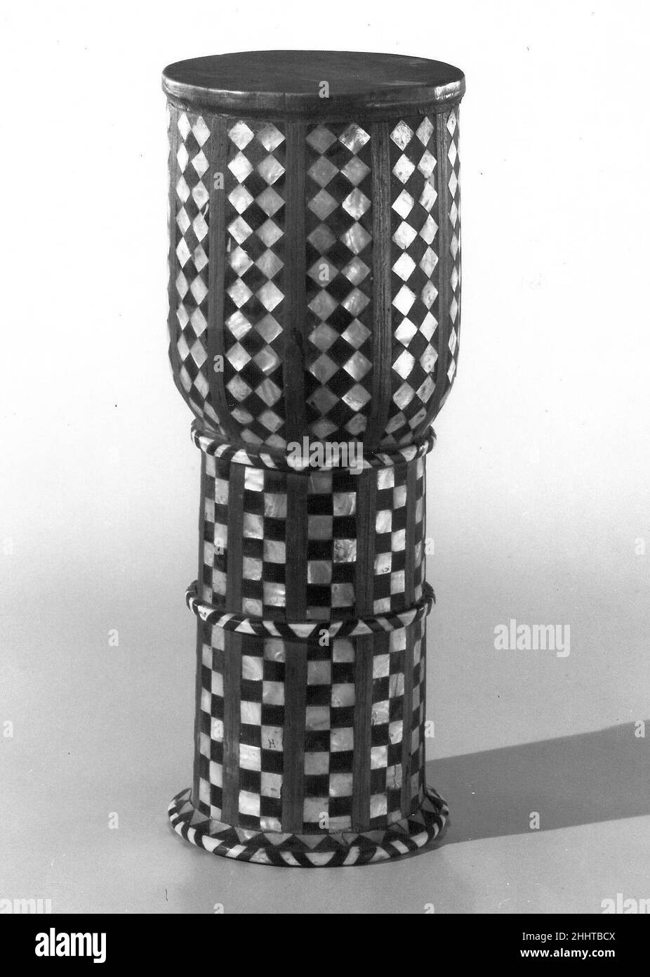 Tombak fin 19th siècle le Darabukka syrien est le terme arabe pour ce tambour à tête unique en forme de goblet qui se trouve en Afrique du Nord, au Moyen-Orient, en Europe de l'est, en Asie du Sud et du Sud-est.Il est connu sous de nombreux noms tels que dombek, tombak, et zarb (Iran) et peut être fait de poterie ou de bois.La technique de jeu utilise des coups légers et lourds, des rouleaux et des boutons-pression sur les différentes sections de la tête pour produire des sons discrets, des articulations et des rythmes.Le tambour peut être tenu sous le bras, suspendu à une sangle et le plus souvent posé sur la cuisse gauche du joueur.Tombak 501813 Banque D'Images