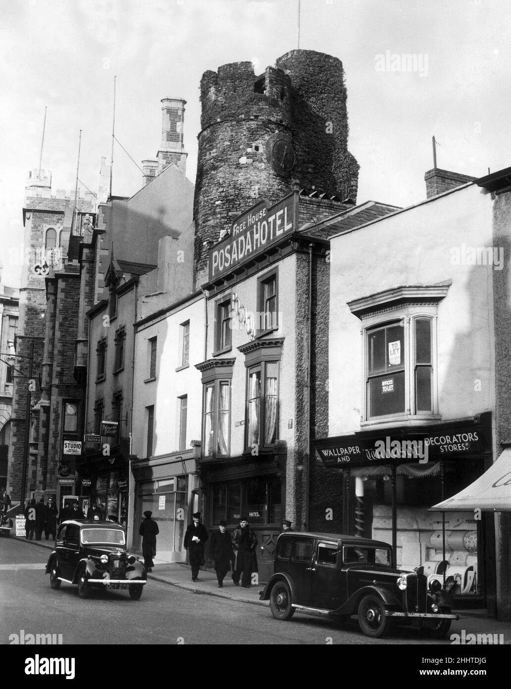 Castle Bailey Street à Swansea le 1940 avril.Un bailey qui colle parmi les toits est tout ce qui reste du château de Swansea.Des donjons souterrains ont été convertis en abris de RAID aérien, pour être utilisés par le public.Une ancienne horloge de la tour est arrêtée depuis plus de 200 ans. Banque D'Images