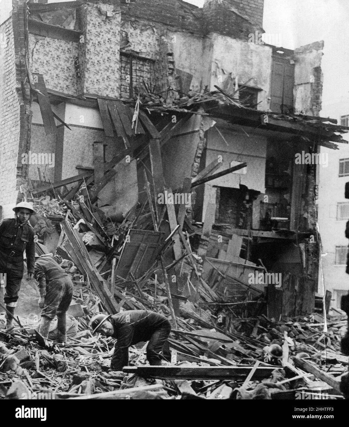RAID aérien Précautions les travailleurs se salvent dans les débris de deux maisons de classe ouvrière bombardées lors d'un récent raid, Sidney place, Edge Hill, Liverpool, en photo le mardi 12th novembre 1940. Banque D'Images