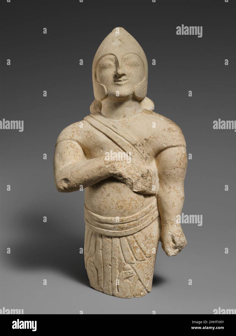 Le guerrier de calcaire de mi-à 3rd quart du siècle 6th C.-B. Cypriote Egyptien et les caractéristiques grecques sont mêlées dans cette figure.Il porte le kilt égyptien avec un casque grec modifié; les formes arrondies souples qui embrassent la tête laissent peu de clarté si le casque est en métal.L'articulation de la musculature, en particulier dans les bras, est une indication supplémentaire de l'influence grecque.Guerrier de calcaire 242151 Banque D'Images