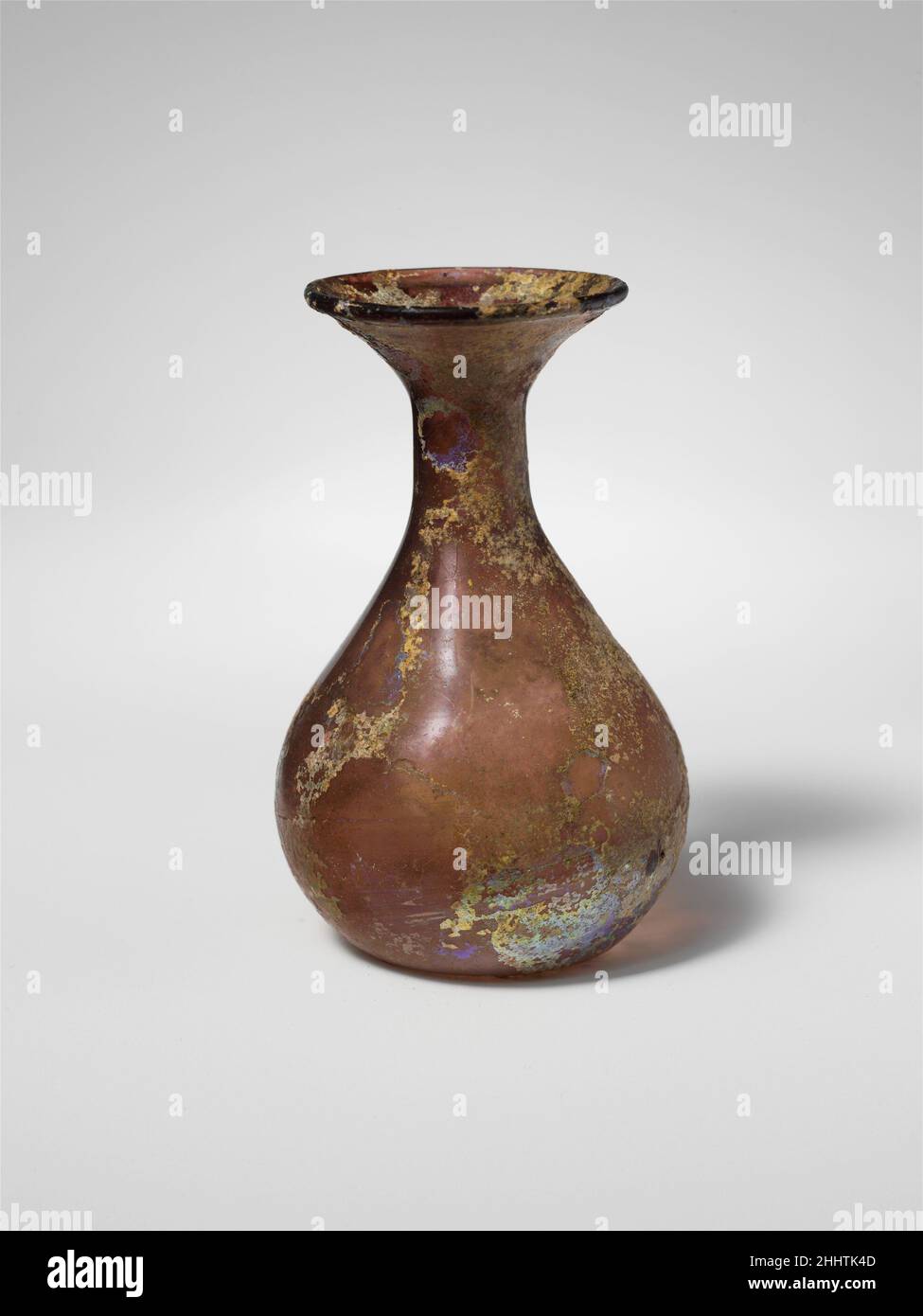 Flacon en verre env.3rd Century A.D. Roman translucide violet clair de manganèse.jante lisse arrondie; large col évasé; col cylindrique court; corps piriforme; fond enfoncé.intact; peu de bulles et de stries soufflantes; piqûres, morcellement et intempéries irisées.Flacon en verre 244709 Banque D'Images