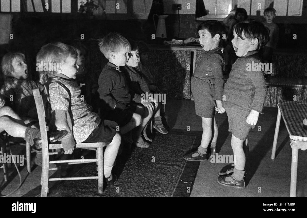 C'est le centre communautaire de Whitley (Reading) qui appelle.Vous écoutez (en théorie) les frères jumeaux de quatre ans Peter et Tony Brownlee lors de leur concert au coucher du lit.Quand le sandman commence sa soirée, les enfants ont leur divertissement de soirée produit par eux-mêmes.nous ne sommes pas tout à fait sûr si madame dans la deuxième rangée des stands se fait plaisir dans un bâillement (pas fait, madame) ou si elle chante, aussi.8th avril 1941 Banque D'Images