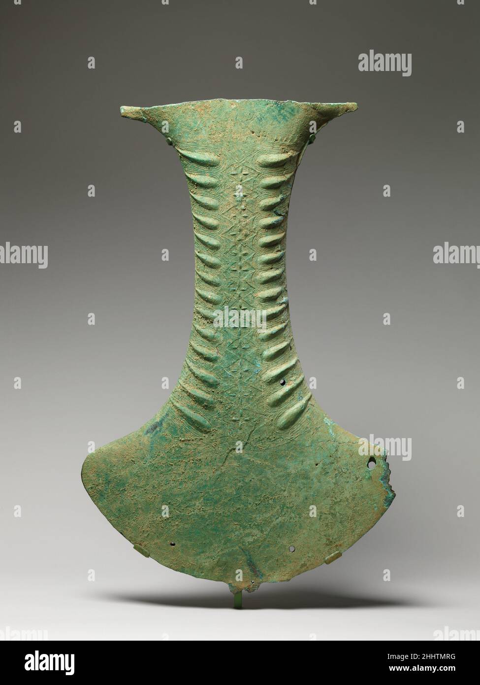 Objet cérémonial sous la forme d'un axe ca.100 C.-B.–A.D.300 Indonésie, peut-être Sulawesi cet objet cérémonial remarquable, une tournée de force conceptuelle aussi bien que technique, a presque certainement fonctionné comme un instrument percussif à suspendre et à frapper.Les stries sur le col à bride, ressemblant aux marques en relief de la peau de crocodile, sont combinées à la répétition de losange et peuvent avoir aidé à fixer la corde à partir de laquelle l'instrument a été suspendu.Une face anthropomorphique avec bandes en spirale et un motif en dents de scie apparaissent au verso.L'objet porte une comparaison étroite avec ce que l'on appelle Makassar Banque D'Images