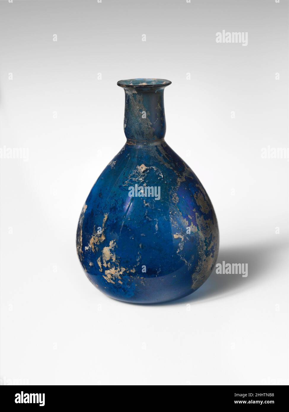 Bouteille de parfum en verre première moitié du 1st siècle A.D. Roman Translucent cobalt bleu.rebord en saillie, avec rebord arrondi au feu; col cylindrique, avec trait horizontal autour de la base; corps piriforme; fond plat, légèrement concave au centre.intact; quelques bulles et stries soufflantes; taches de morcellement, d'altération crémeuse, et d'iridescent.Flacon de parfum en verre 245423 Banque D'Images