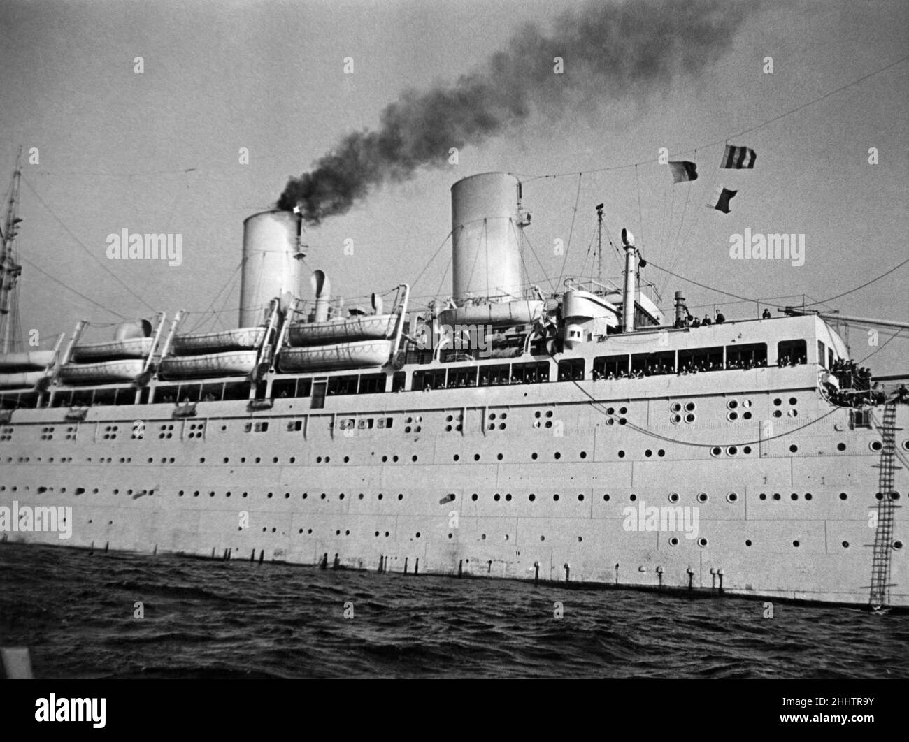 Les troupes longeant le pont de promenade de l'Empire Windrush tandis qu'elle s'éloigne de l'embouchure de la Tamise lors de son long voyage au Moyen-Orient.Le transport de 14 000 tonnes aujourd'hui, dirigé par la New Zealand Shipping Company, était avant la deuxième guerre mondiale, utilisé pour des croisières en Allemagne d'avant-guerre, puis comme un navire de troopship allemand et comme navire de mère à des sous-marins allemands, avant d'être capturé par les Britanniques et pris comme un prix de guerre.Juin 1947 P015023 Banque D'Images