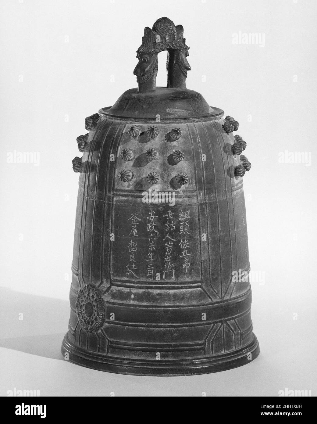 Densho (??)env.1856 Japonais dans les cérémonies japonaises, des cloches en fonte suspendues sont utilisées pour signaler pendant la prière et pour appeler les bouddhistes à adorer.En Chine, des cloches similaires ont été employées dans des ensembles, où elles représentaient le principe du yin, ou principe de « perception », et ont été sonnées après le battement d'un gros tambour (yang, ou élément « créatif »).Le densho incorpore de nombreux motifs symboliques trouvés en extrême-Orient.La boucle de suspension (ryuzo) est formée par deux têtes de dragon et une flamme; le tiers supérieur contient des mamelons (nyu), symboles de fertilité; et le champ stérile en dessous (ikenomachi) fournit un Banque D'Images