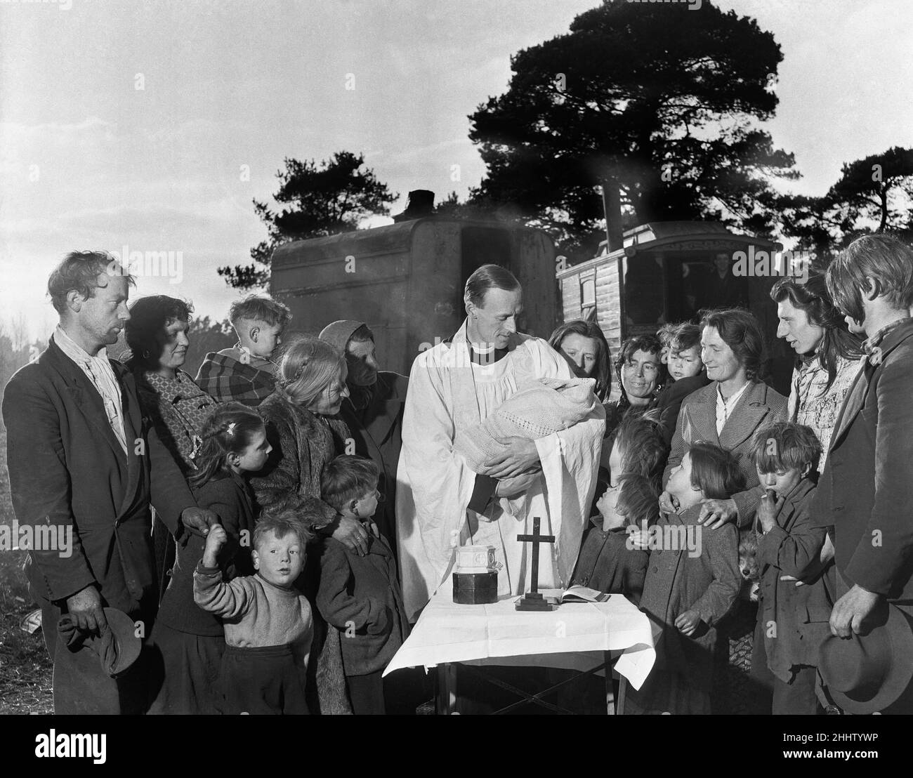 Le vicaire marcha vers le camp tzigane dans le bois.Quand il est au même niveau que la caravane principale, il a appelé: «Je suis le parson local.Je suis arrivé juste à passer, et je me suis demandé s'il y avait quelque chose que je pourrais faire pour aider."Quelques jours plus tard, un message a été livré au vicaire en pierre à Eridge Green, Sussex, il a dit : ' certains des gitans dans le bois aimerait être baptisé.'Ainsi le vicaire, le révérend John Stuart Yorke, a sorti sa vieille voiture.Dans le dos, il a mis une table pliante, un toile d'autel, une petite croix et une police portable.Quand il est arrivé à la forêt, il a mis en place une sma Banque D'Images