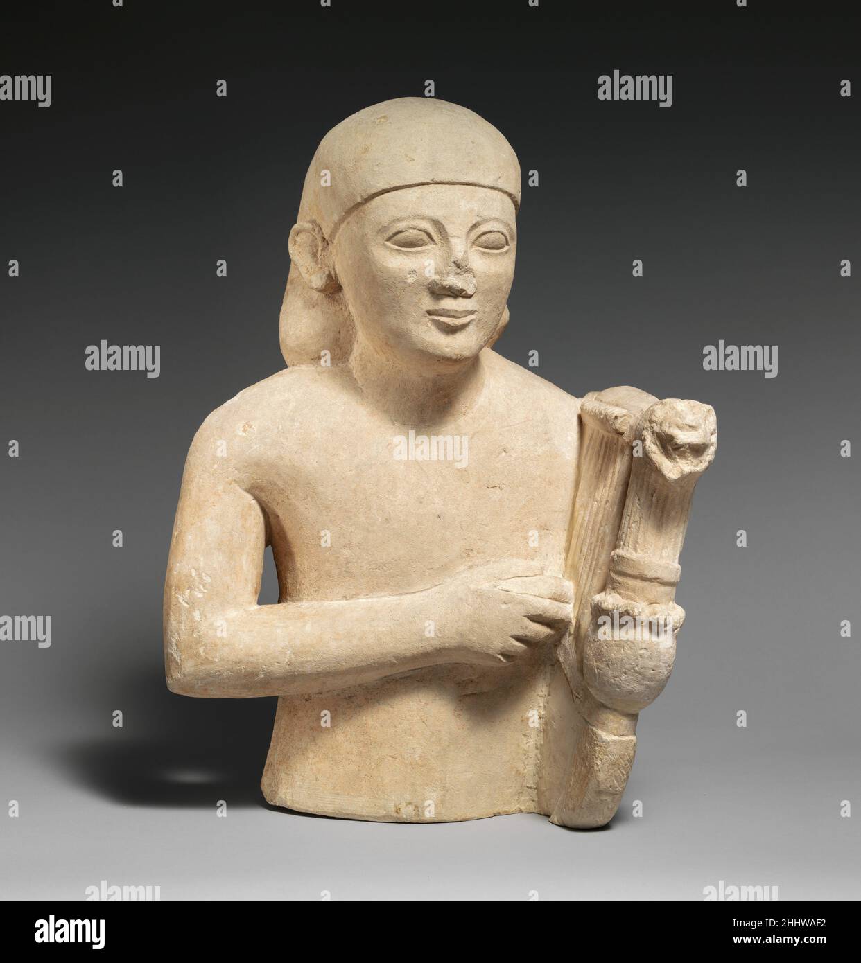Buste en calcaire d'un joueur de lyre ca.575–550 C.-B. l'influence égyptianisante chypriote est évidente dans la perruque et la posture dure.Au sommet de la lyre se trouve une tête d'un griffon.Cette figure peut avoir formé une paire avec le lecteur de flûte 74.51.2517.À l'origine, les deux représentations auraient été en pleine longueur.Buste en calcaire d'un lyre-joueur 242060 Banque D'Images