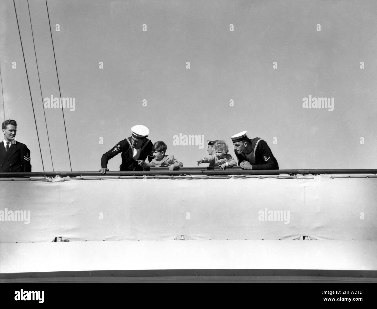 Les enfants royaux, le prince Charles et la princesse Anne, regardent leur mère, la reine et le père, duc d'Édimbourg, des rails du yacht royal Britannia.Elizabeth II et le duc d'Édimbourg sont en visite à Gibraltar, ce fut leur dernier port d'appel de ce tour royal.10th mai 1954. Banque D'Images