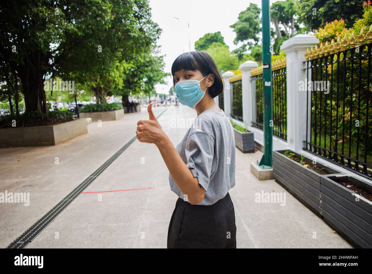 Une femme asiatique portant un masque médical se déplace dans les lieux publics Banque D'Images