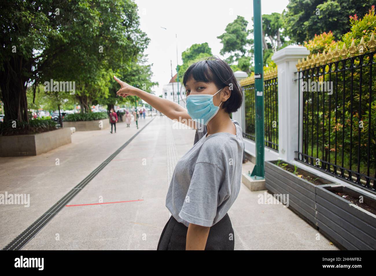 Une femme asiatique portant un masque médical se déplace dans les lieux publics Banque D'Images